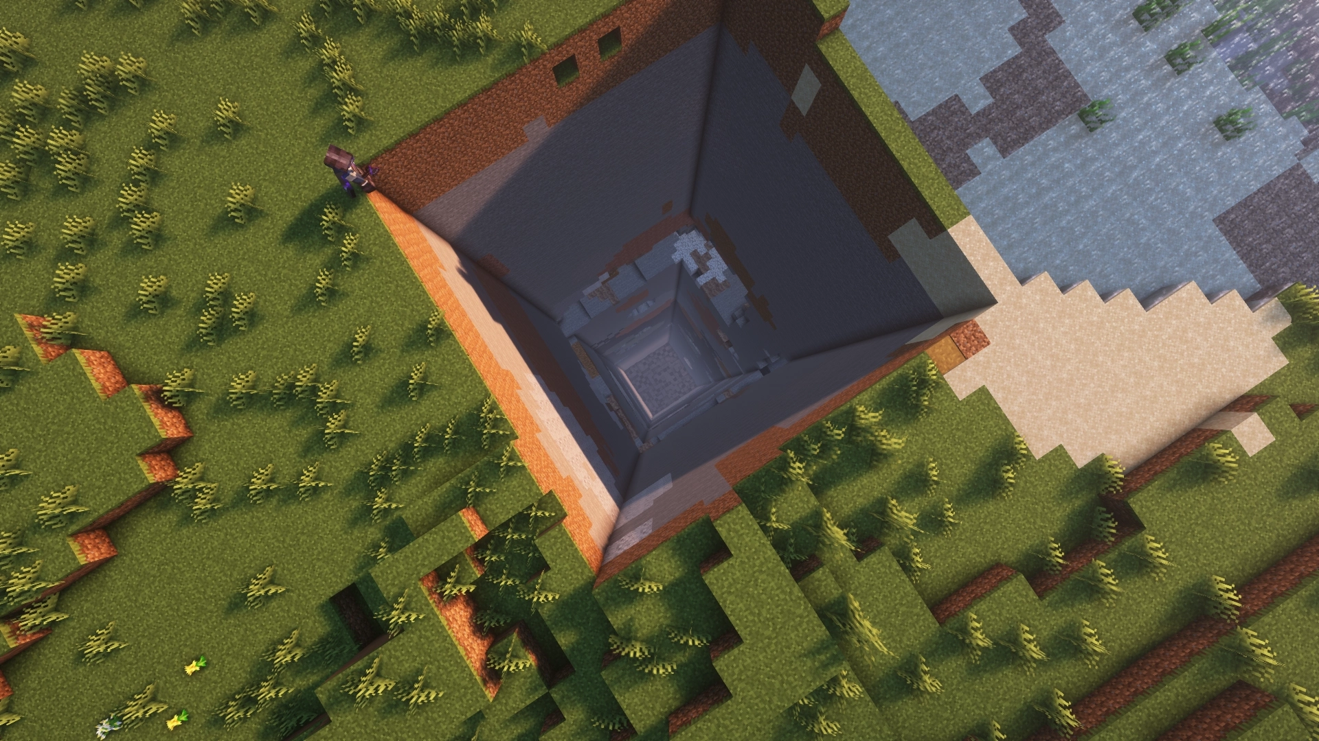 A top down shot of my Minecraft character standing next to a one chunk big hole straight down to bedrock